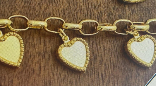 Gold bracelet with heart-shaped charms on a wooden surface